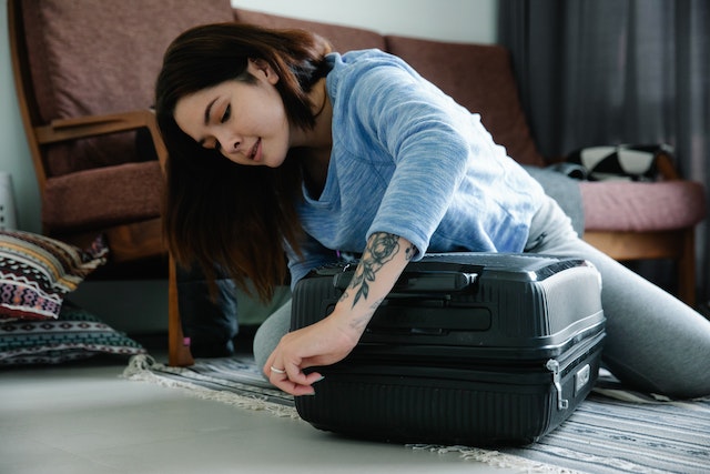 woman-zipping-a-suitcase