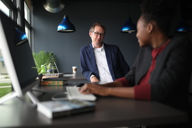 man and woman near standing desks