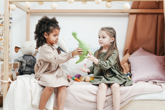 two-girls-play-with-dinosaur